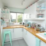 White suite with a wooden countertop for the kitchen with lots of windows