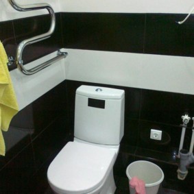 ห้องน้ำสีขาวบนพื้นหลังกระเบื้องสีดำ