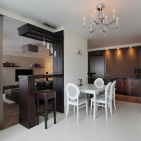 Balcão de bar de madeira escura em uma cozinha-sala brilhante