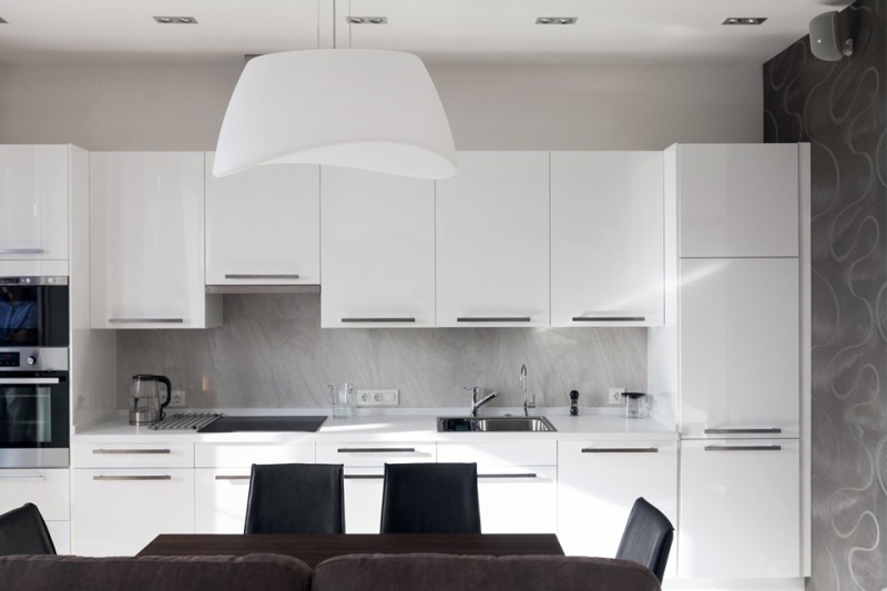 ผ้ากันเปื้อนสีเทาจากแผง mdf ในห้องครัวพร้อมชุดสีขาว