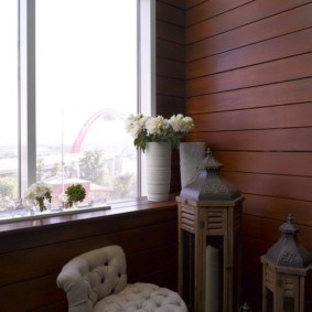 แจกันกับดอกไม้สดบน windowsill ของระเบียง