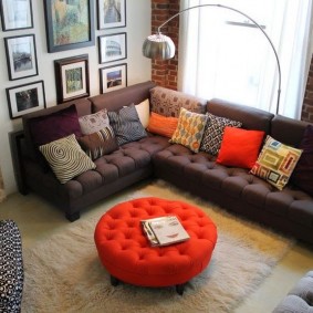 pouf สีแดงที่ด้านหน้าของโซฟาในห้องนั่งเล่น